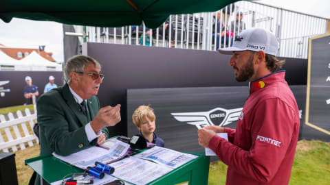 Max Homa and announcer Alistair Scott with a local child on the 1st tee during a practice round prior to the 2022 Genesis Scottish Open