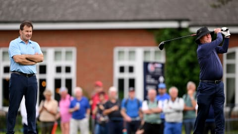 JP McManus tees off on the 10th hole as Sir Nick Faldo of England looks on during the Celebrity Pro-Am