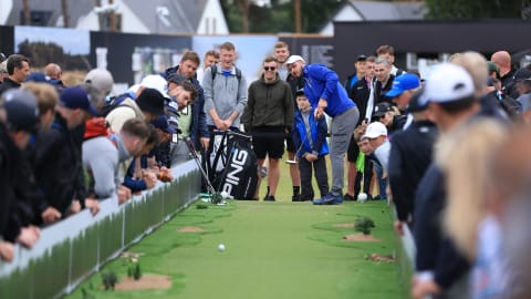 Spectators playing the Long Putt Challenge in the Championship Village