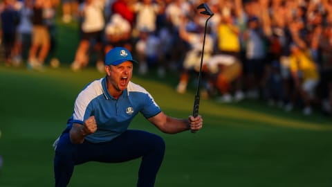 Justin Rose celebrates holing a birdie putt on the 18th green to secure a tie in Friday's four-balls