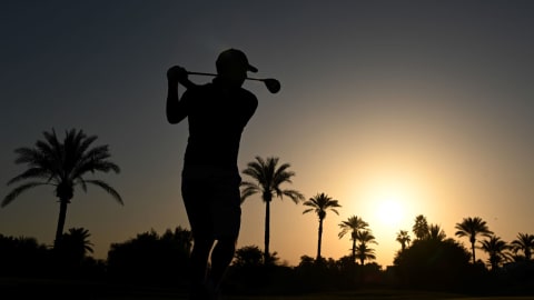 Sergio Garcia hits a tee shot as the sun rises in Dubai