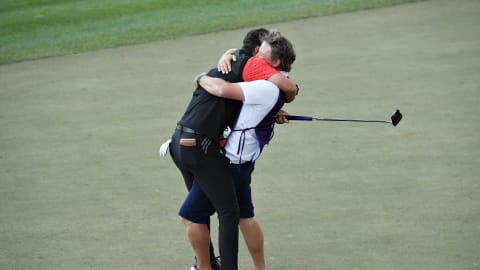 Lucas Herbert celebrates with his caddie after victory