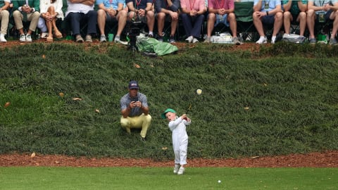 Axel Brooks plays his shot from the ninth tee, with father Billy watching on
