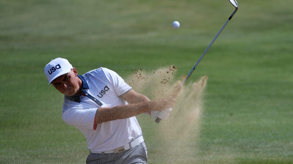 Rickie Fowler plays out of a bunker on the third hole