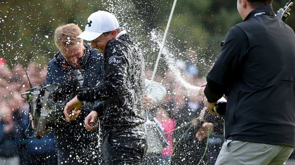 Matthew Fitzpatrick of England is sprayed with sparkling wine as he celebrates on the 18th after final round of the British Masters