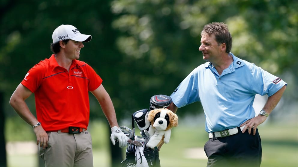 Rory McIlroy of Northern Ireland (L) talks with caddie J.P. Fitzgerald during practice at Firestone