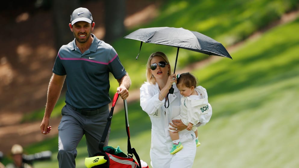 Charl Schwartzel walks with his wife Rosalind and their daughter during the Par 3 Contest ahead of the 2015 Masters Tournament 