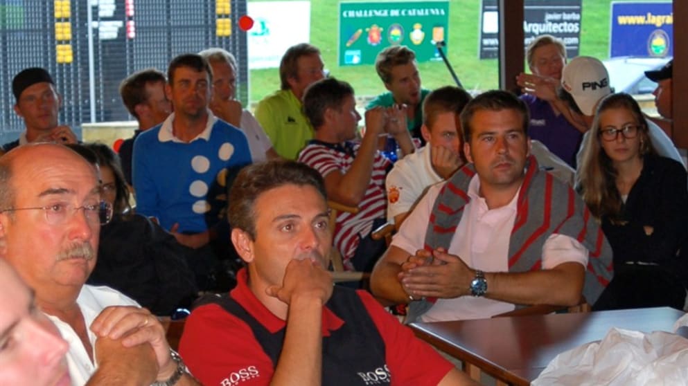 Players and fans watch The Ryder Cup on TV during the play suspension which causes the third round of the Challenge de Catalunya to be abandoned