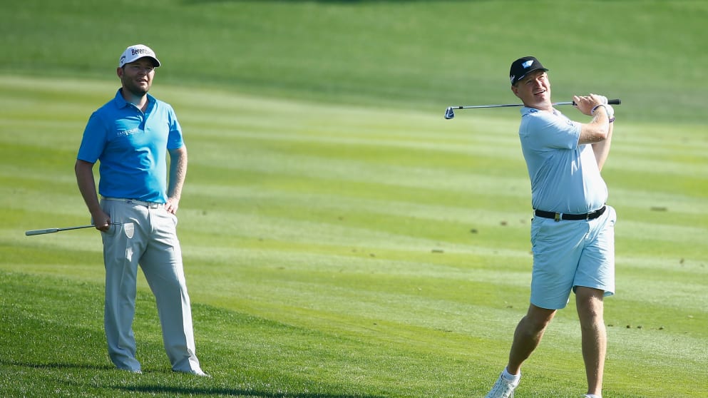 Branden Grace and Ernie Els of South Africa watch a shot during a practice round prior to the start of the Abu Dhabi HSBC Golf Championship
