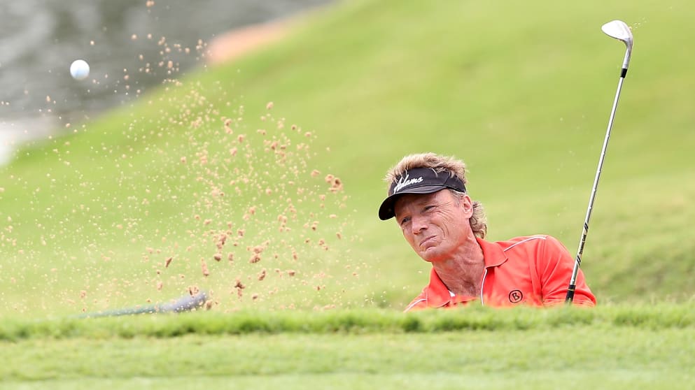 Bernhard Langer chips from the bunker onto the 16th green 