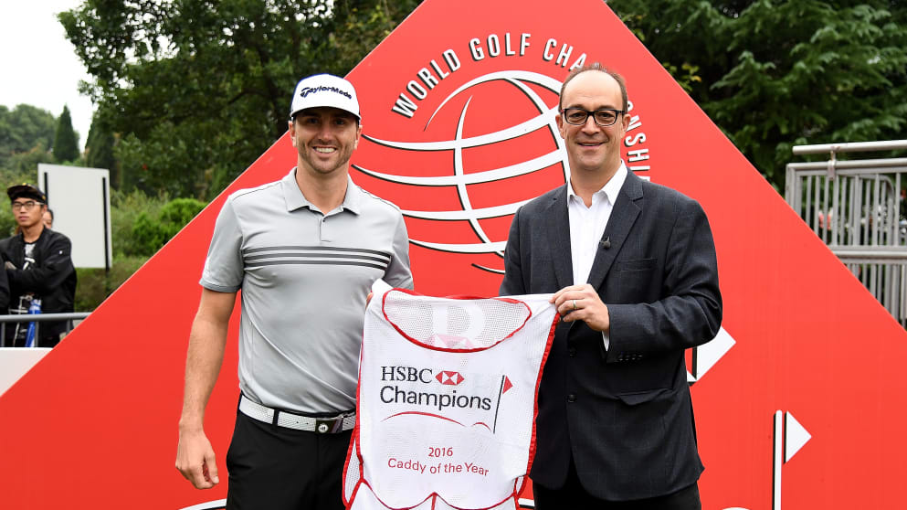 HSBC Global Head of Sponsorship and Events Giles Morgan presents Austin Johnson with his caddy of the year bib at the WGC-HSBC Champions