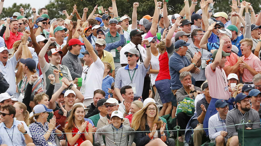 Patrons cheer on the 18th green after Tiger Woods win the Masters