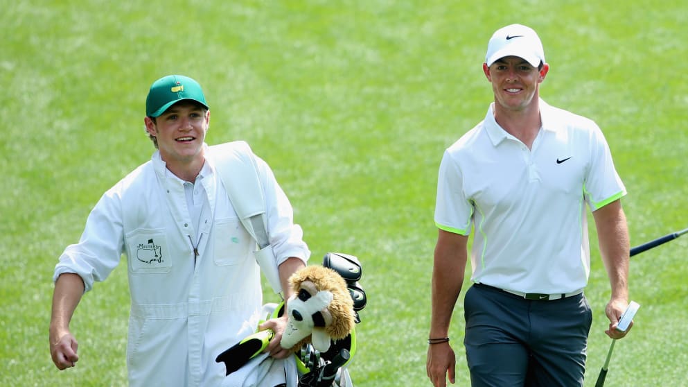 Rory McIlroy walks alongside his caddie Niall Horan of the band One Direction during the Par 3 Contest at the Masters Tournament