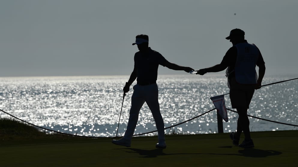 Mike Lorenzo-Vera  hands a card to his caddie