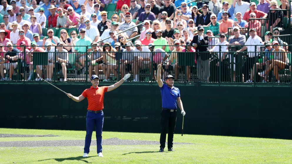 Danny Willett and Tyrrell Hatton react after skipping their golf balls successfully across the water at 16 at Augusta