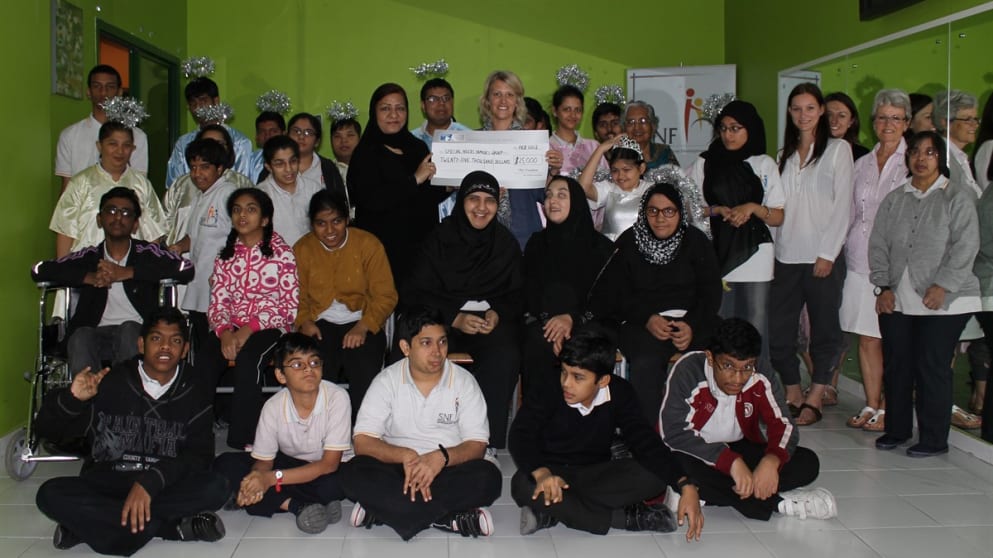 Emma Stenson presents SNF Group Founder Mrs Shafia Bari with the cheque for $25,000 with staff and children in attendance