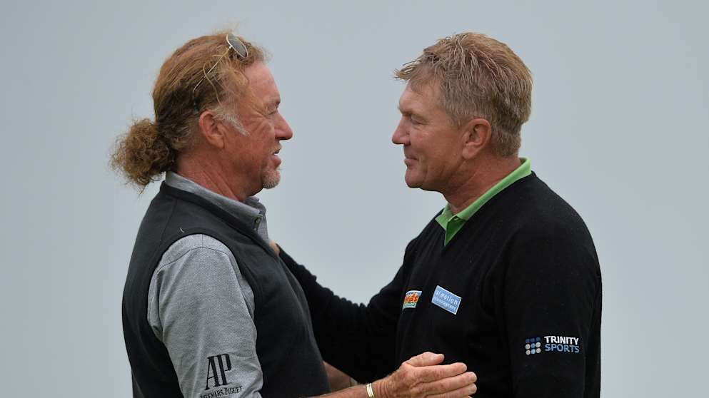 Paul Broadhurst (R), of England is embraced by playing partner Miguel Angel Jimenez of Spain after his final putt on 18 to win The Senior Open Championship presented by Rolex
