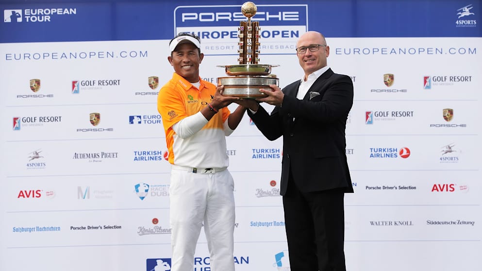 Thongchai Jaidee of Thailand is presented with the winners trophy by Bernhard Maier member of the board, sales and marketing Porsche AG after victory at the European Open