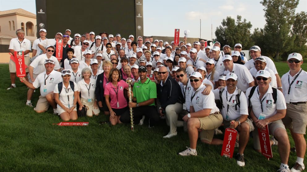 Volunteers pose with 2011 champion Alvaro Quiros