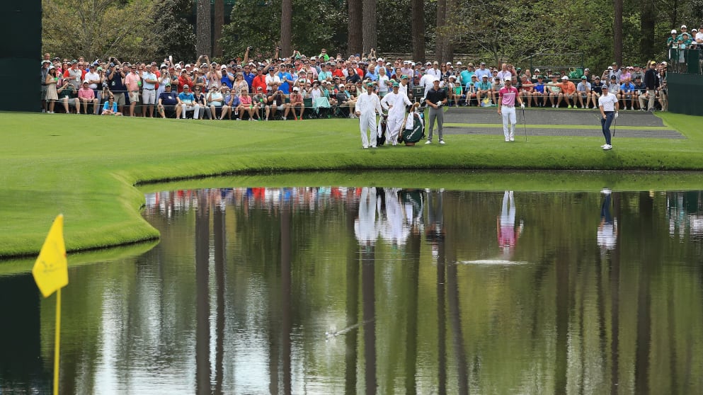 Rory McIlroy skips a ball on the pond on the 16th