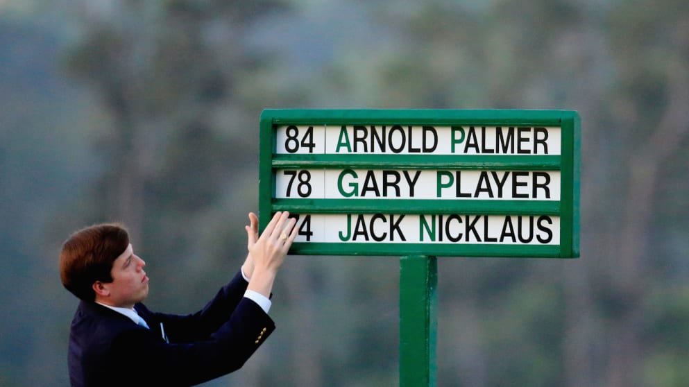 Justice Taylor places the names of the three honorary starters on the first tee 