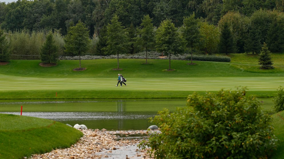 Players walk along the 13th fairway