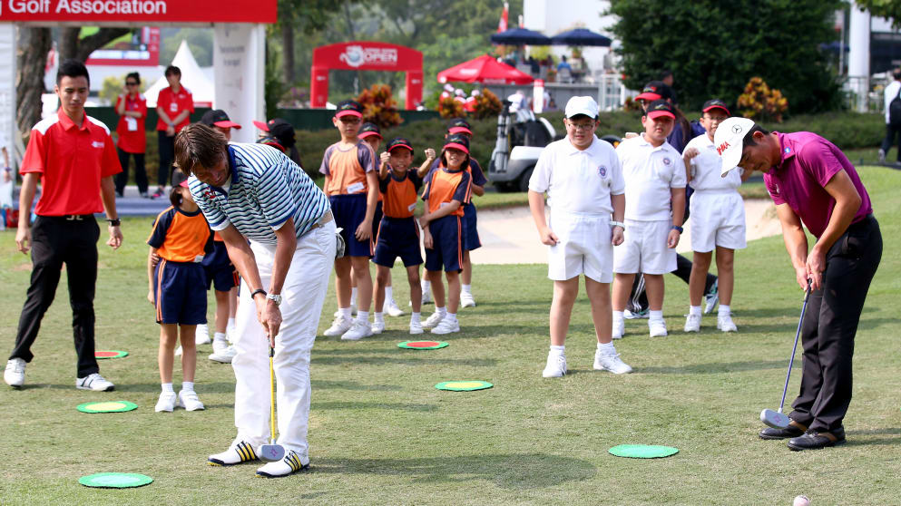 Robert Jan Derksen and Liang Wen-Chong of China take part in a kids golf clinic at the Hong Kong Open 