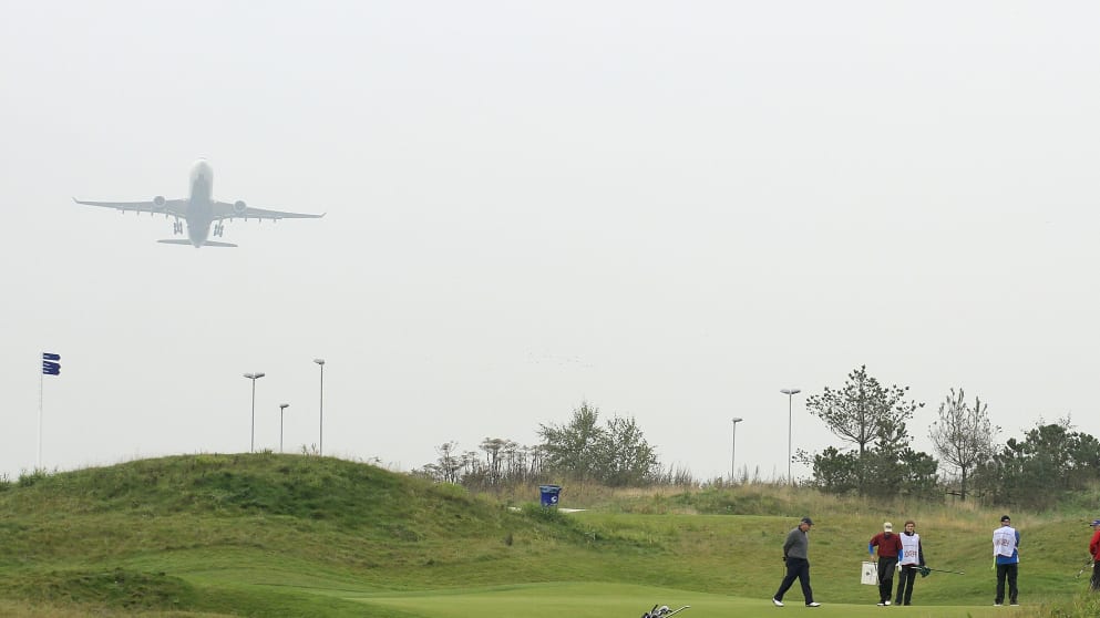 A group on the 12th green while a plane takes off from Schiphol Airport