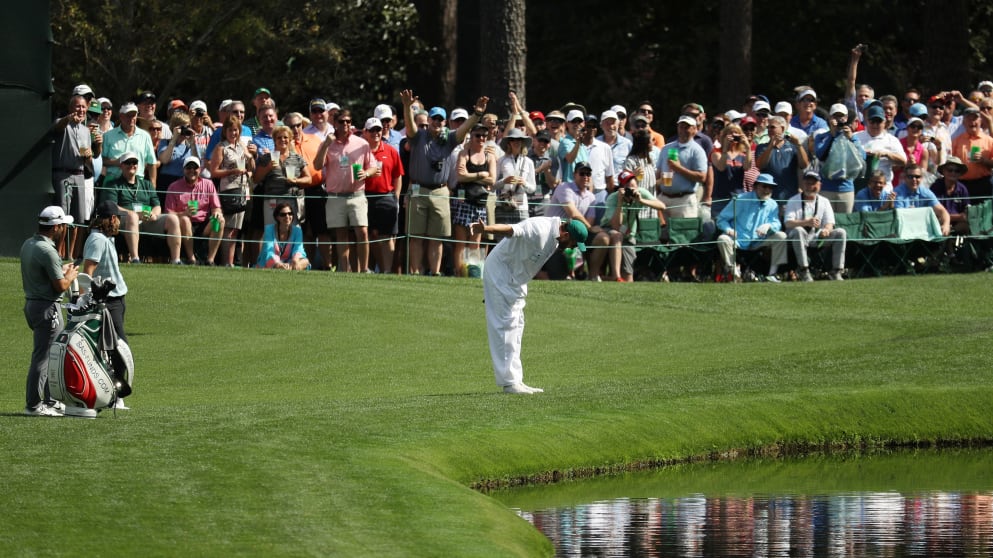 Tommy Fleetwood of England's caddie Ian Finnis skips a ball on the 16th