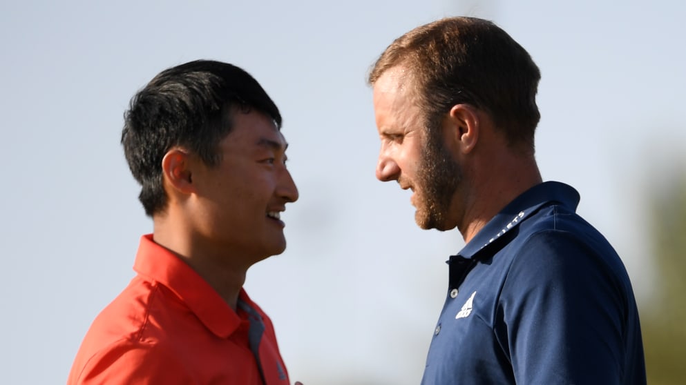 Dustin Johnson shakes hands with Li Haotong