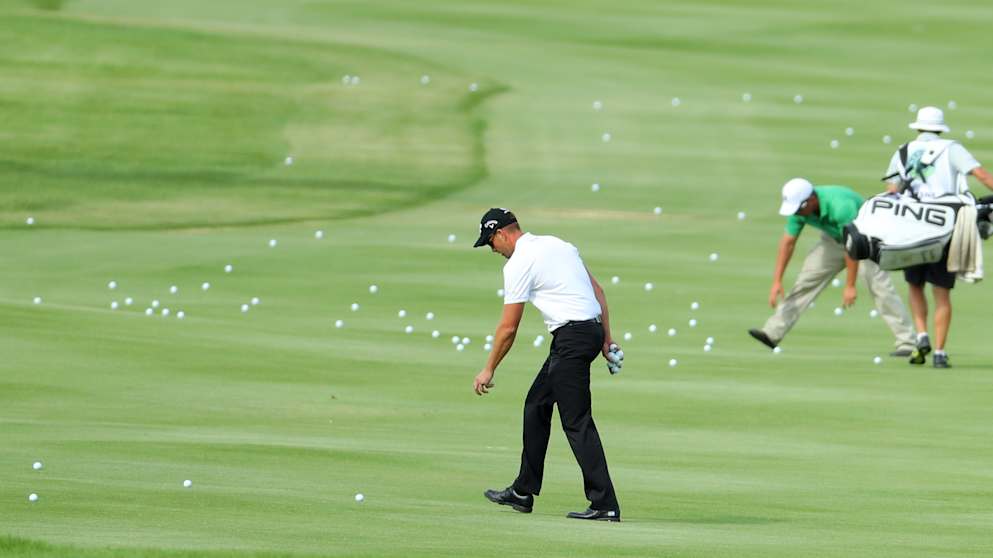 Henrik Stenson helps to collect balls at the Nedbank Golf Challenge