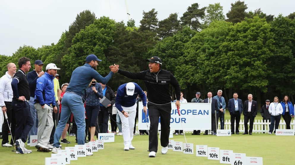 Byeong Hun An celebrates the winning putt with Jamie Redknapp