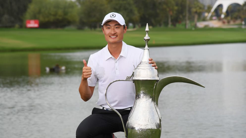 Li Haotong of China celebrates victory with the trophy 