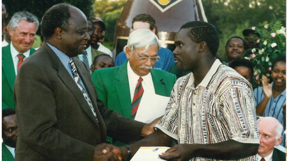 Jacob Okello receives a pay cheque after the 1998 Kenya Open 