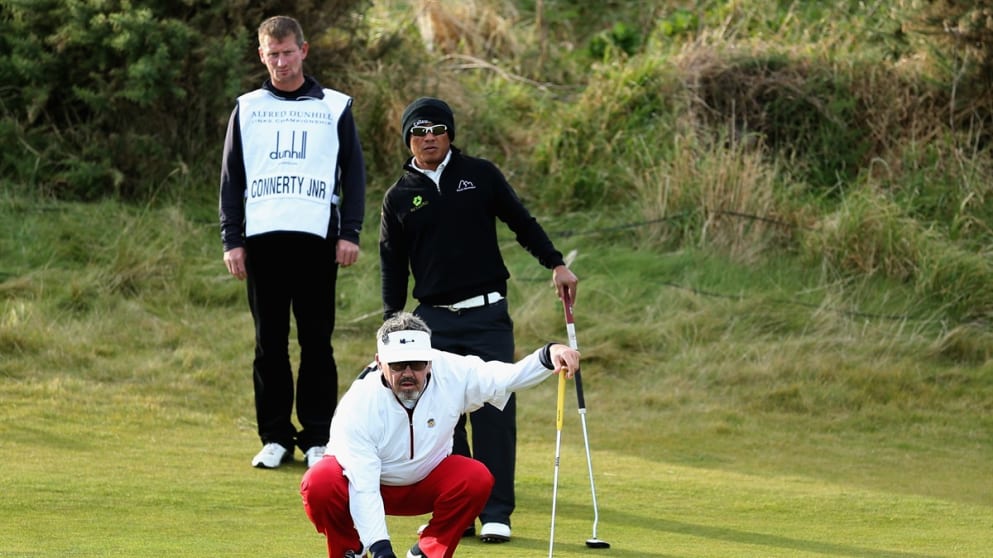 Hugh Connerty Jr lines up a putt with partner Thongchai Jaidee at Kingsbarns