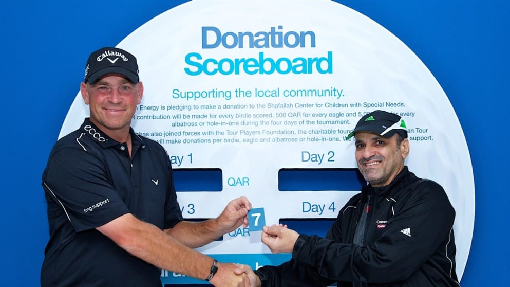 Thomas Bjorn and Adel Ahmed Albuainain, General Manager, Dolphin Energy, Qatar update the donation scoreboard during the first day’s play