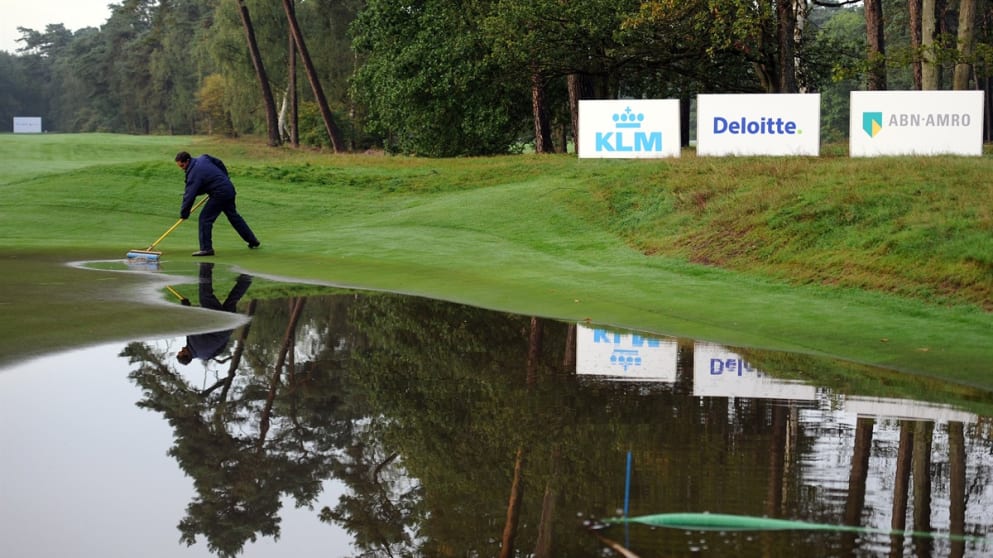 Tournament Director Miguel Vidaor helps clear the eighth green