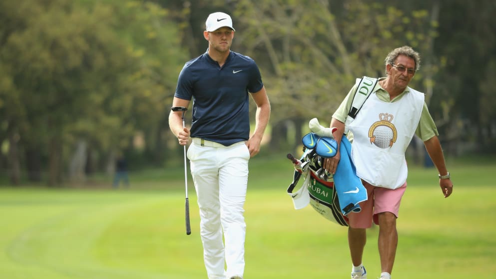 Joshua White walks with his caddie Pedro Ramseyer on the 18th green at the Trophee Hassan II